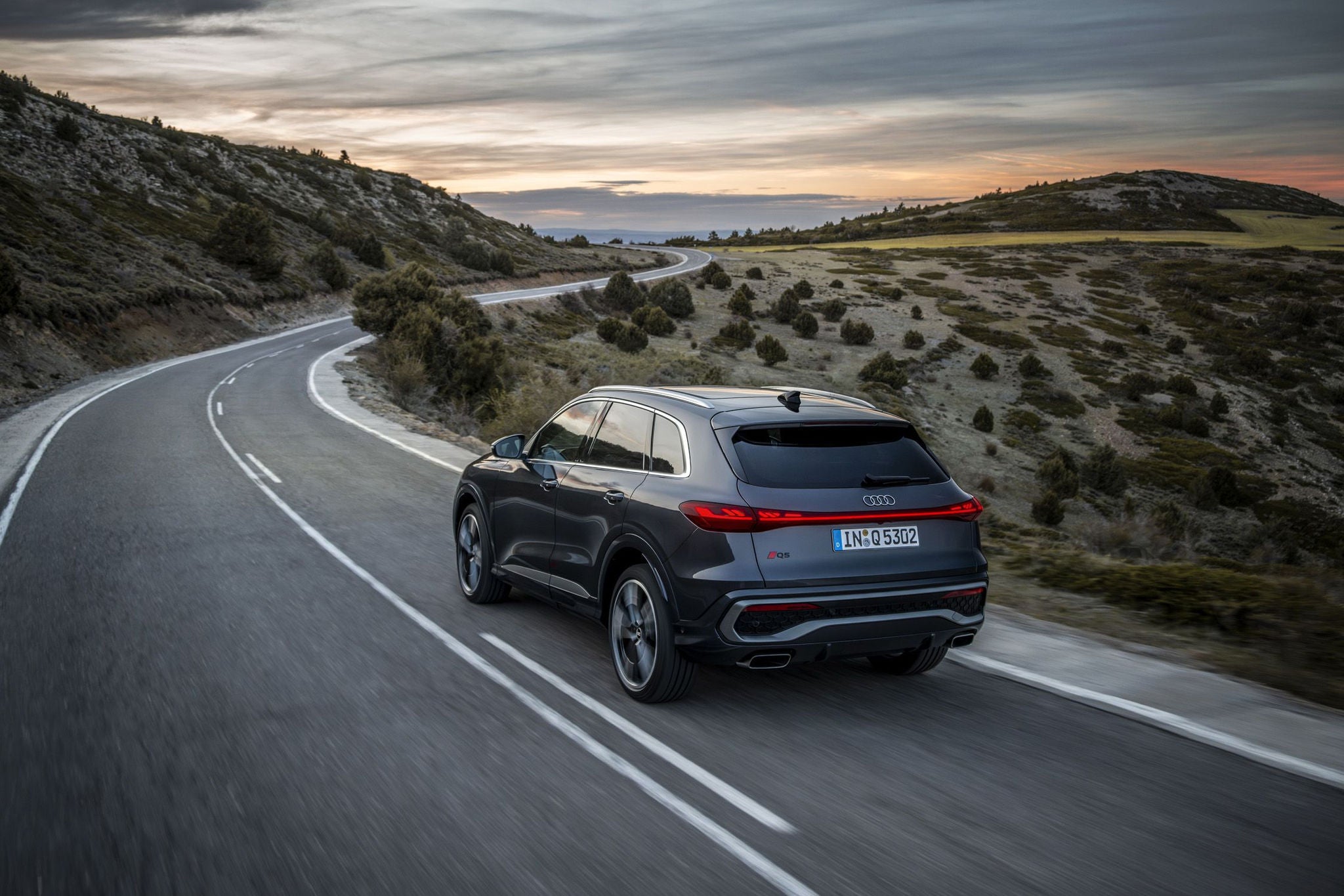 Rear shot of the 2025 Audi Q5 driving through mountains 